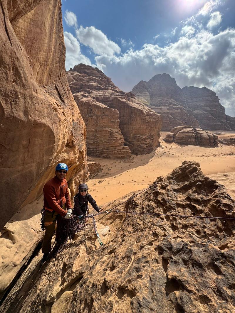 Climbing guide and guest on a sandstone ridge in Wadi Rum